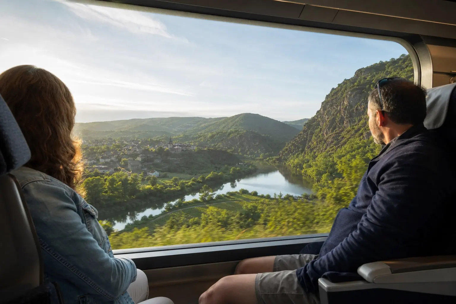 Voyageurs à bord d’un train traversant une vallée française